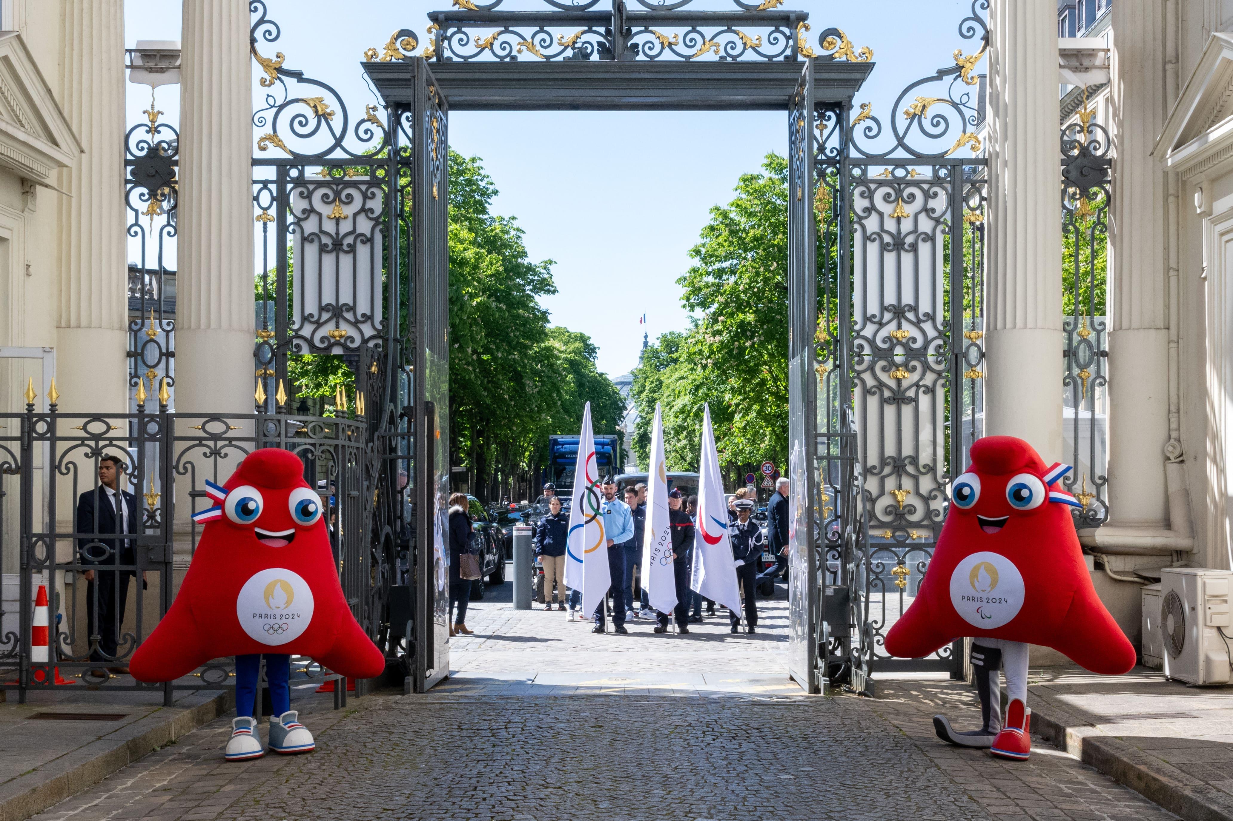 Mascottes officielles des Jeux olympiques et drapeaux devant la grille de l'hôtel de Beauvau