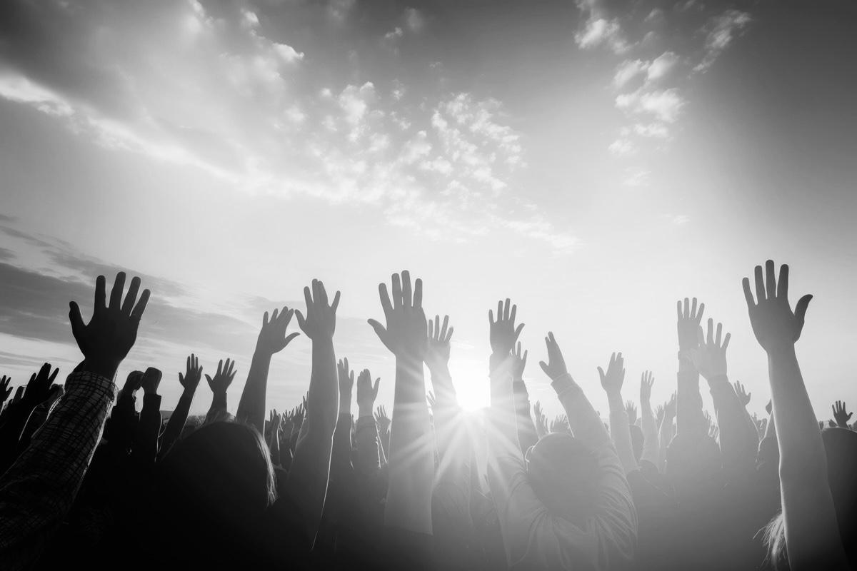 Groupe de personnes les mains levées vers le ciel, en noir et blanc